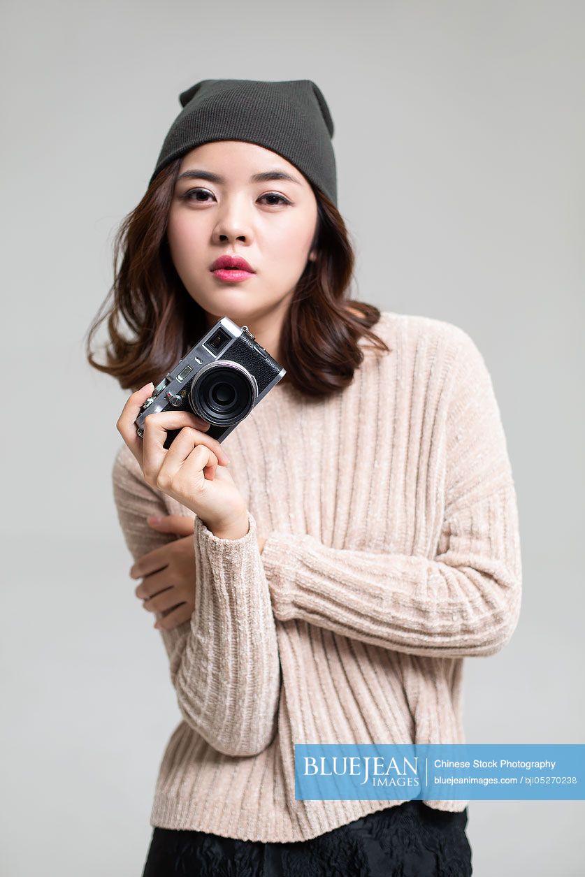 Young Chinese woman holding camera