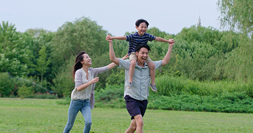 快乐年轻家庭在草地上玩耍