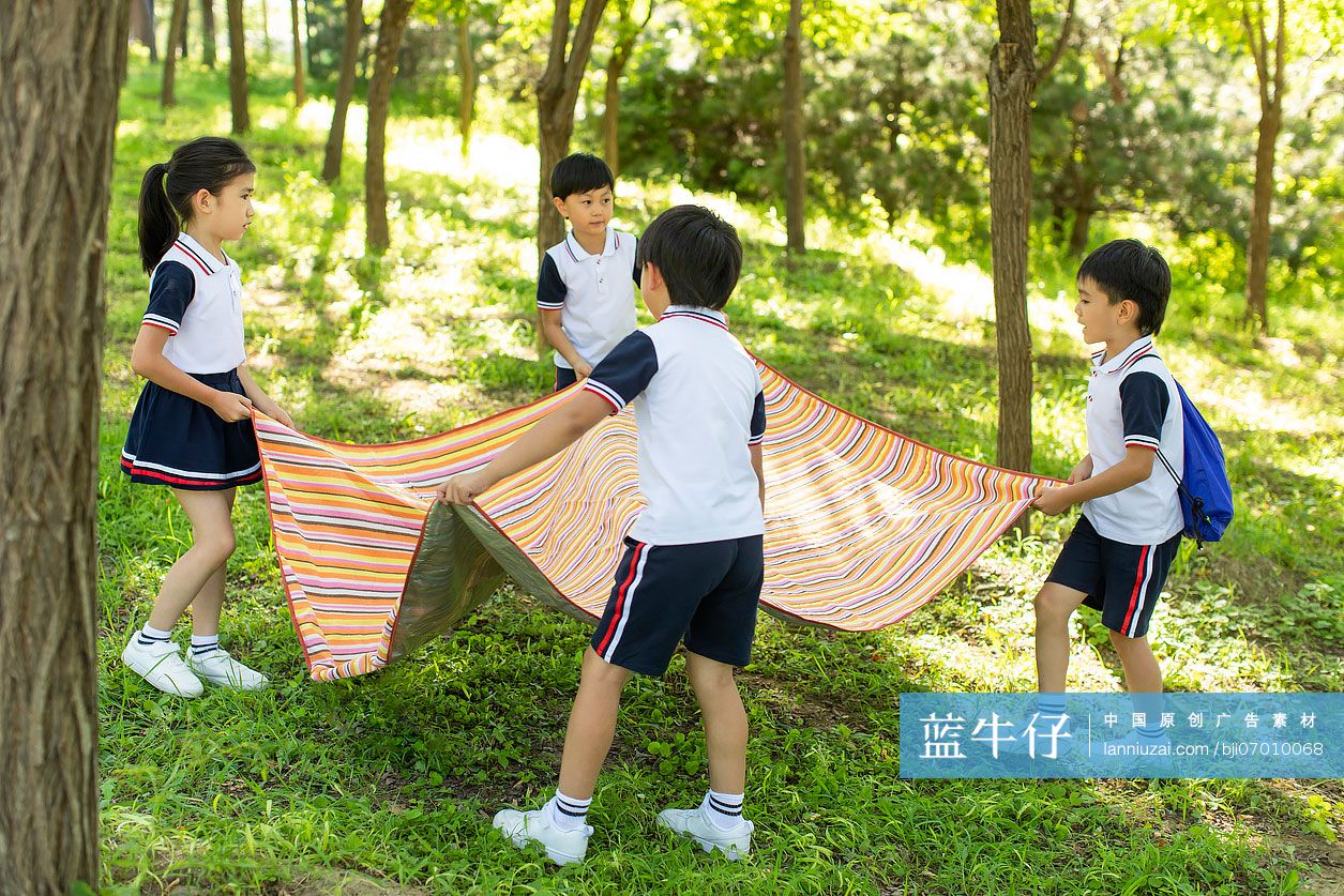 快乐的小学生铺野餐垫