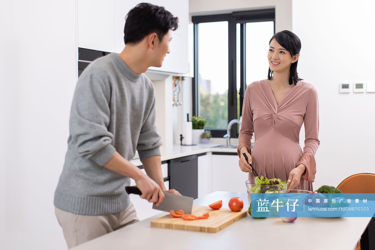 快乐的年轻准父母在家做饭