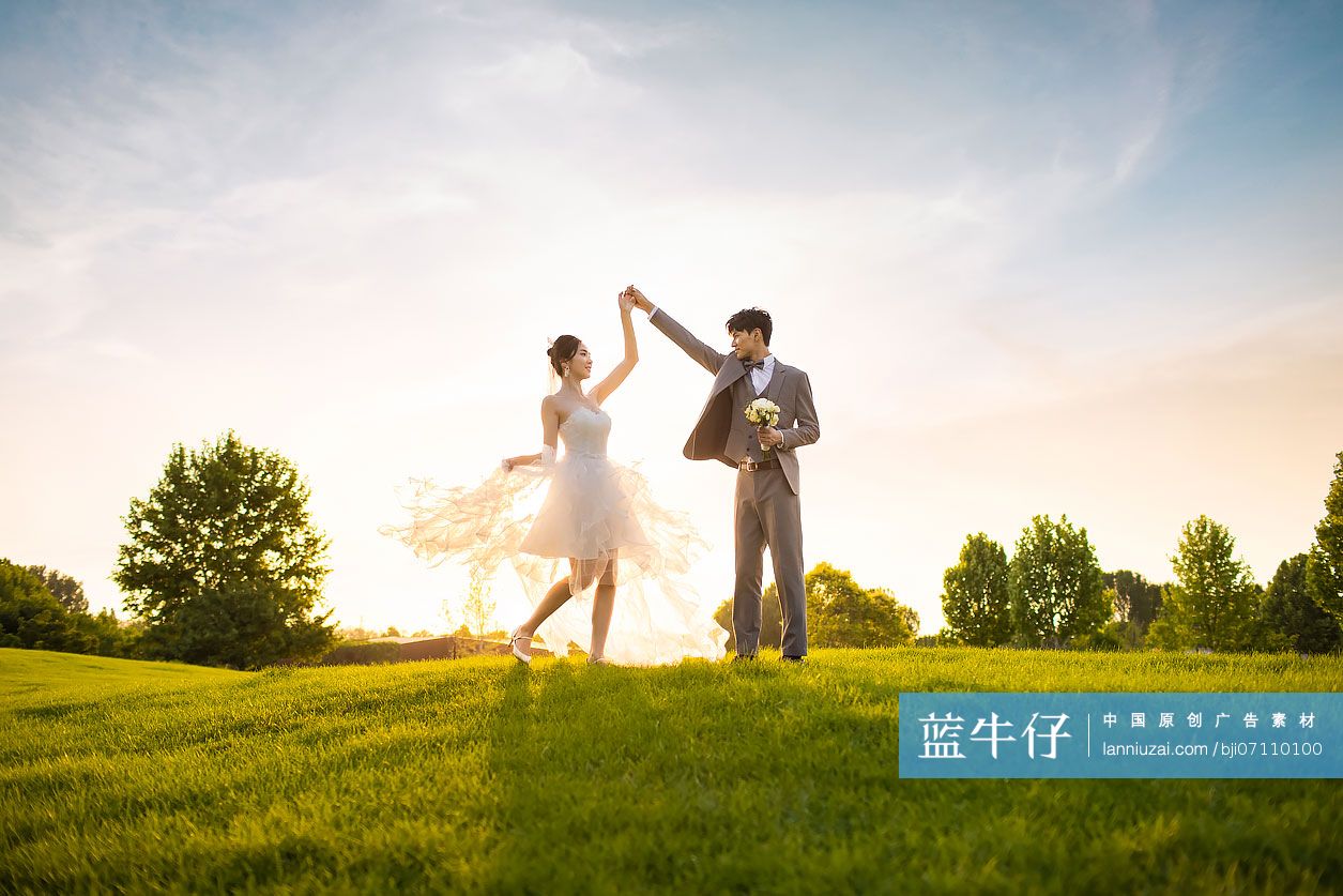 快乐的新郎新娘在草地上跳舞