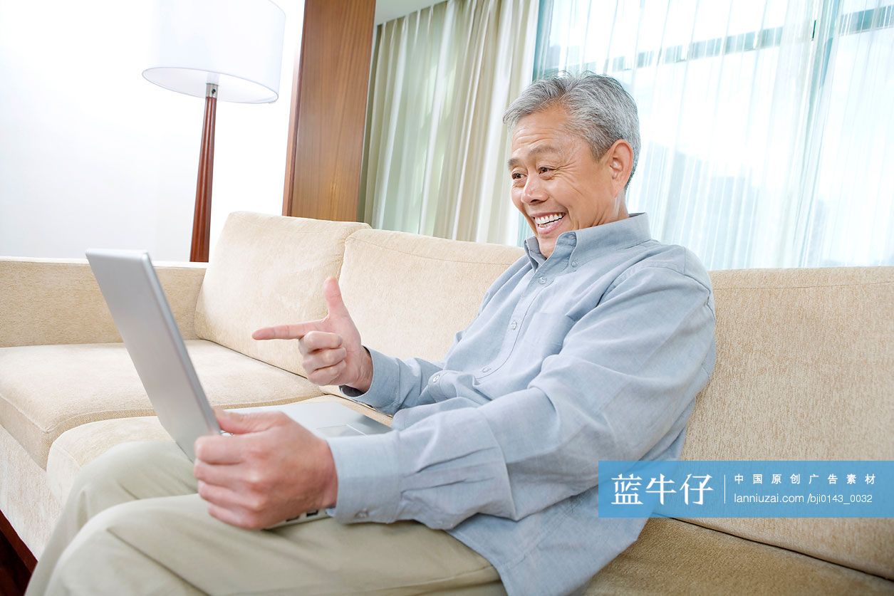 老年人在沙发上用笔记本电脑上网