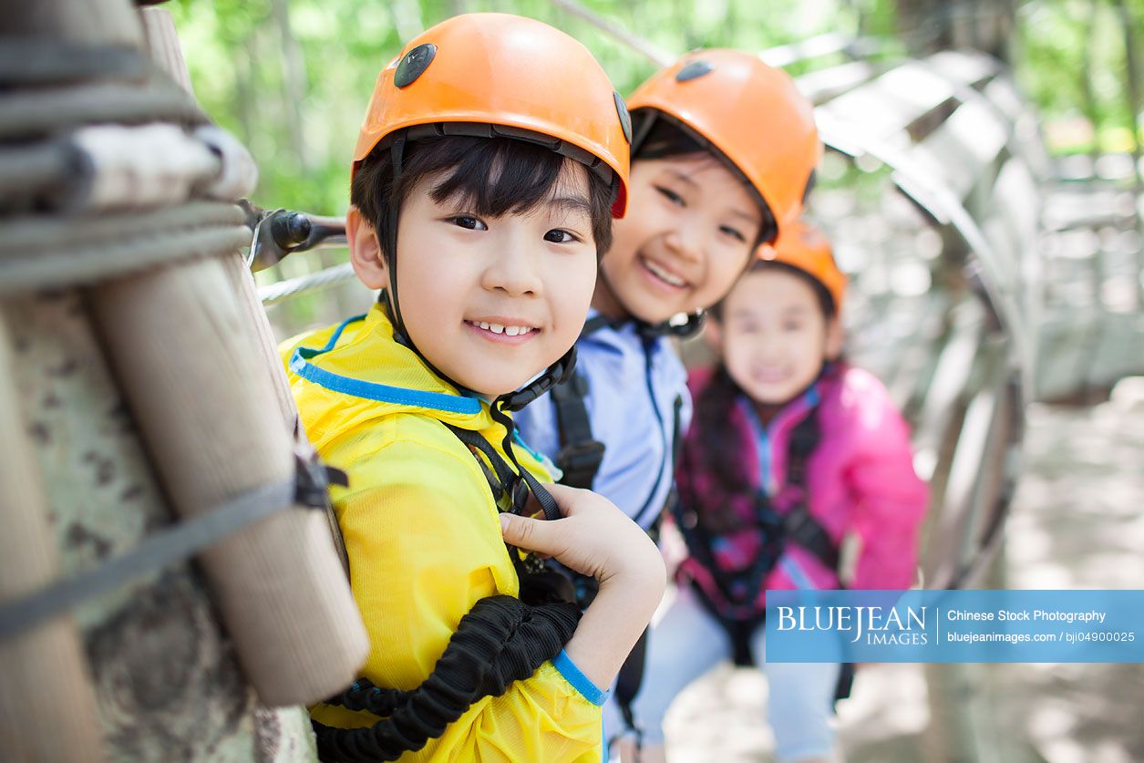Happy Chinese children playing in tree top adventure park