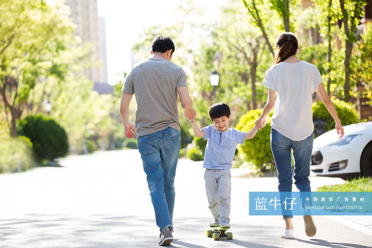 快乐的年轻家庭在户外玩滑板