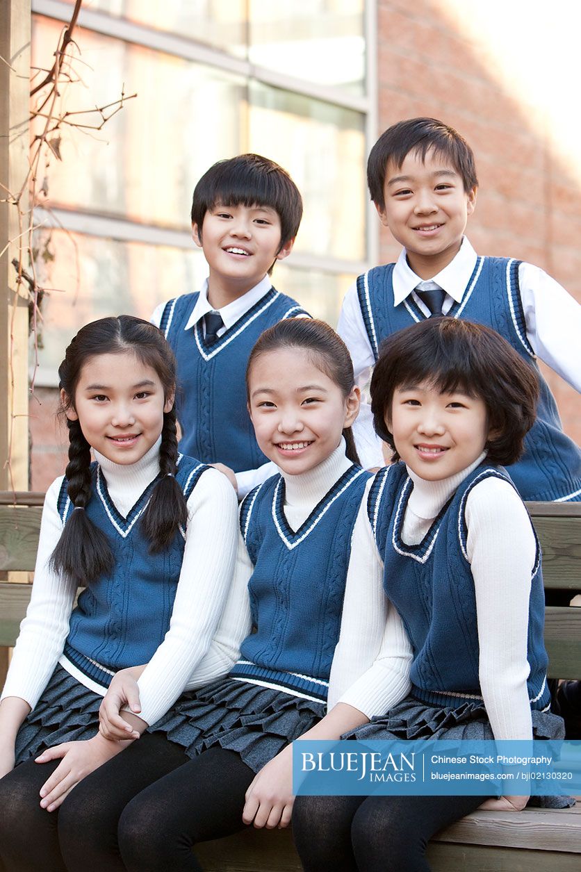 Five Chinese students sitting together on a bench