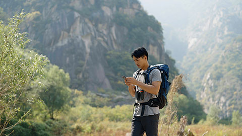 Young Chinese man hiking outdoors