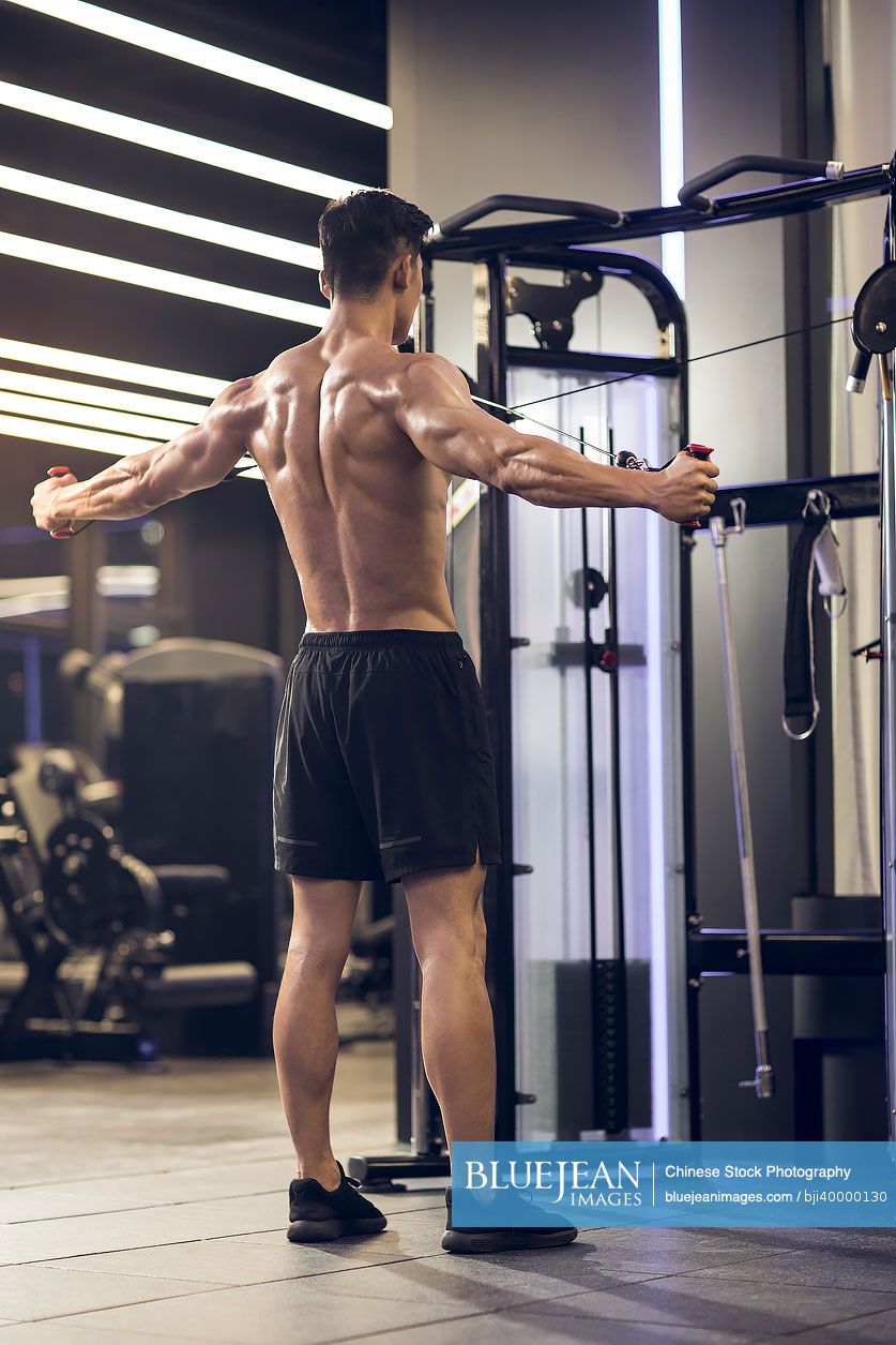 Young Chinese man exercising at gym