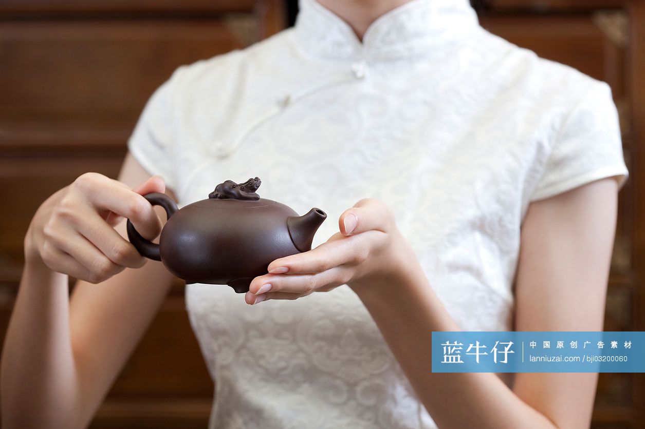 女人手捧紫砂壶