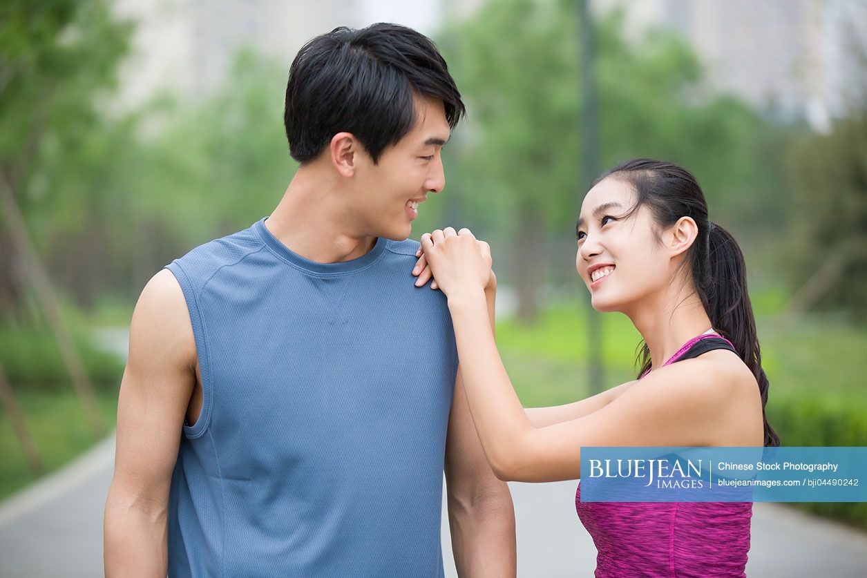 Young Chinese couple taking a break from exercise to talk