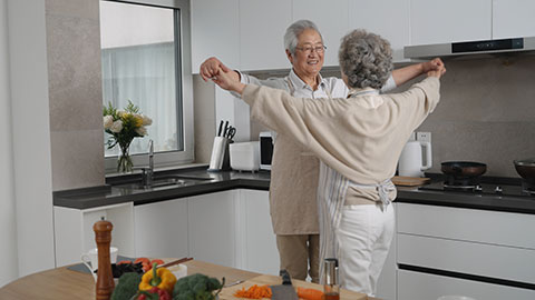 Cheerful senior Chinese couple dancing in kitchen,4K