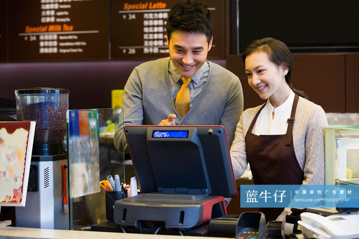 咖啡店店主与店员使用收银机