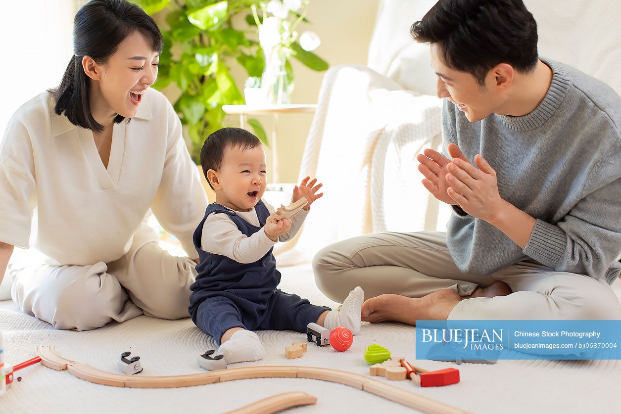 Young Chinese parents playing with baby at home