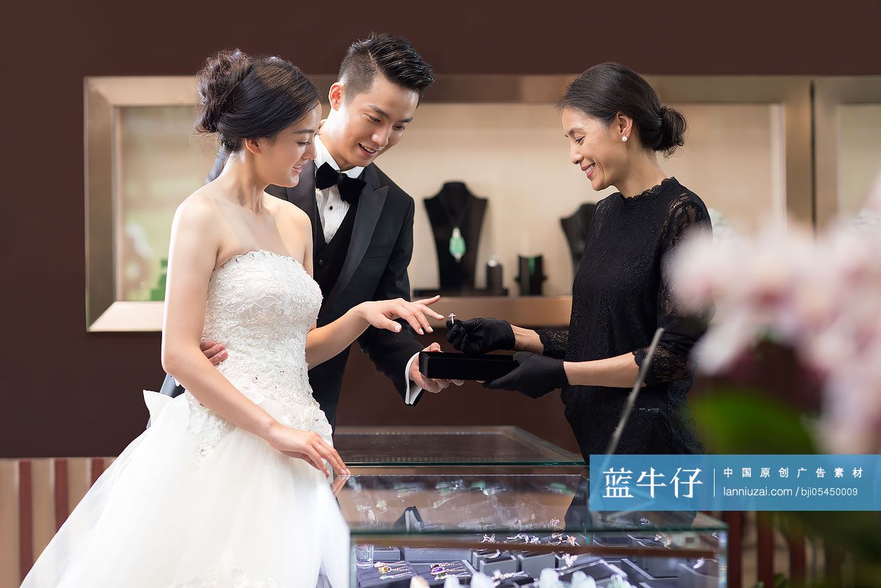 幸福的新娘和新郎在珠宝店挑选戒指