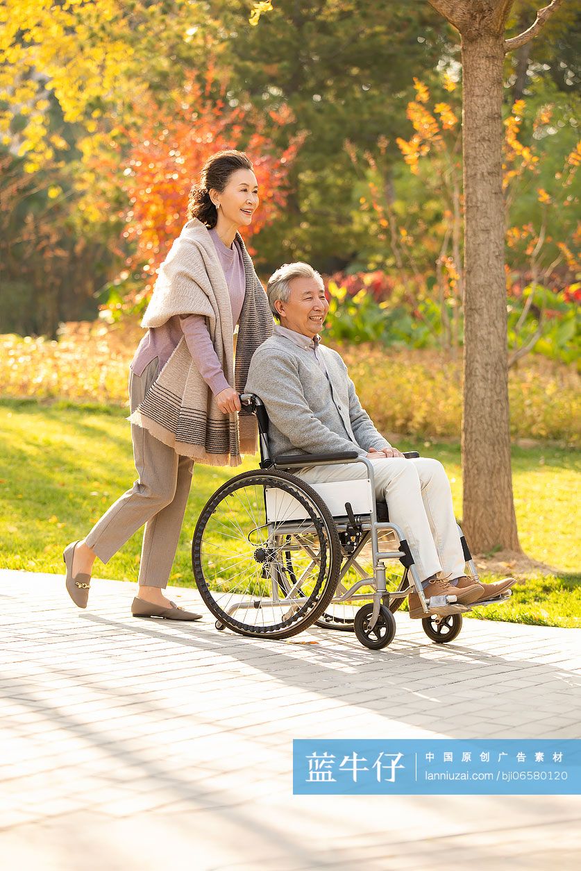 老人推着坐轮椅的老伴逛公园