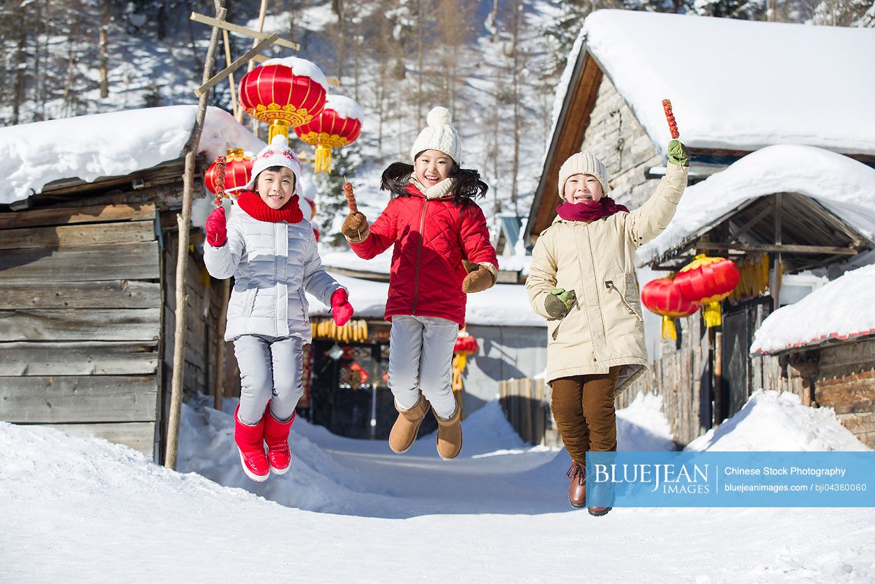 Happy Chinese children jumping with candied haws