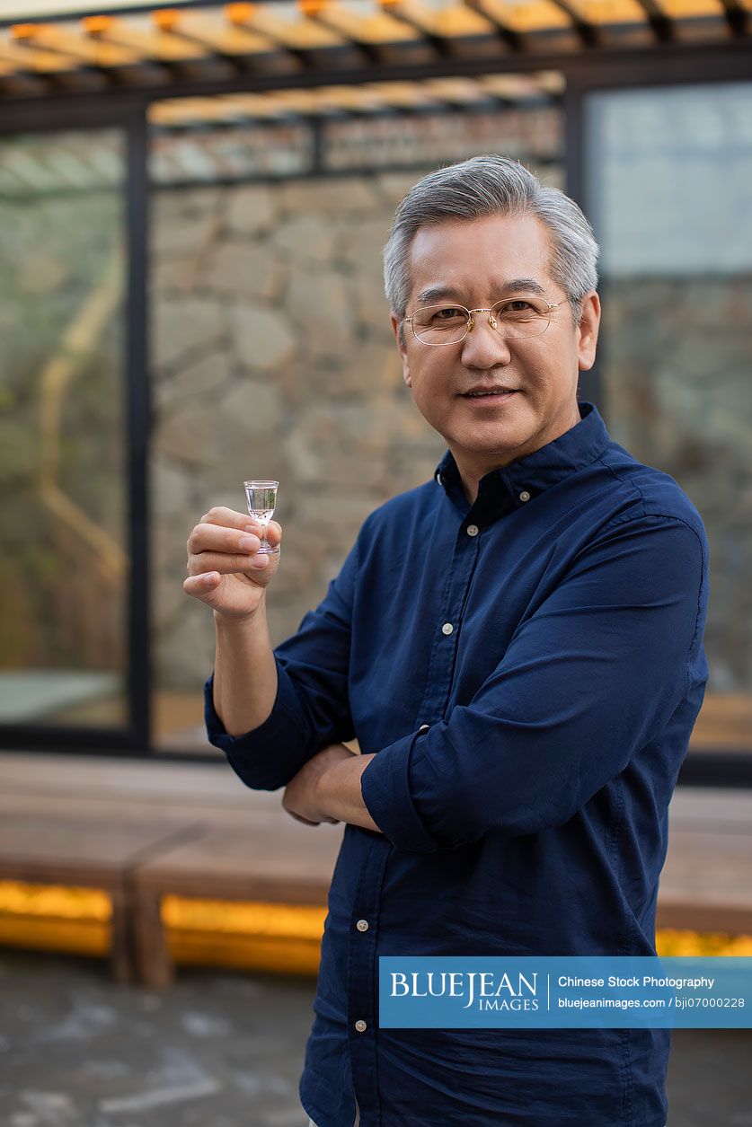 Mature man drinking Chinese spirits