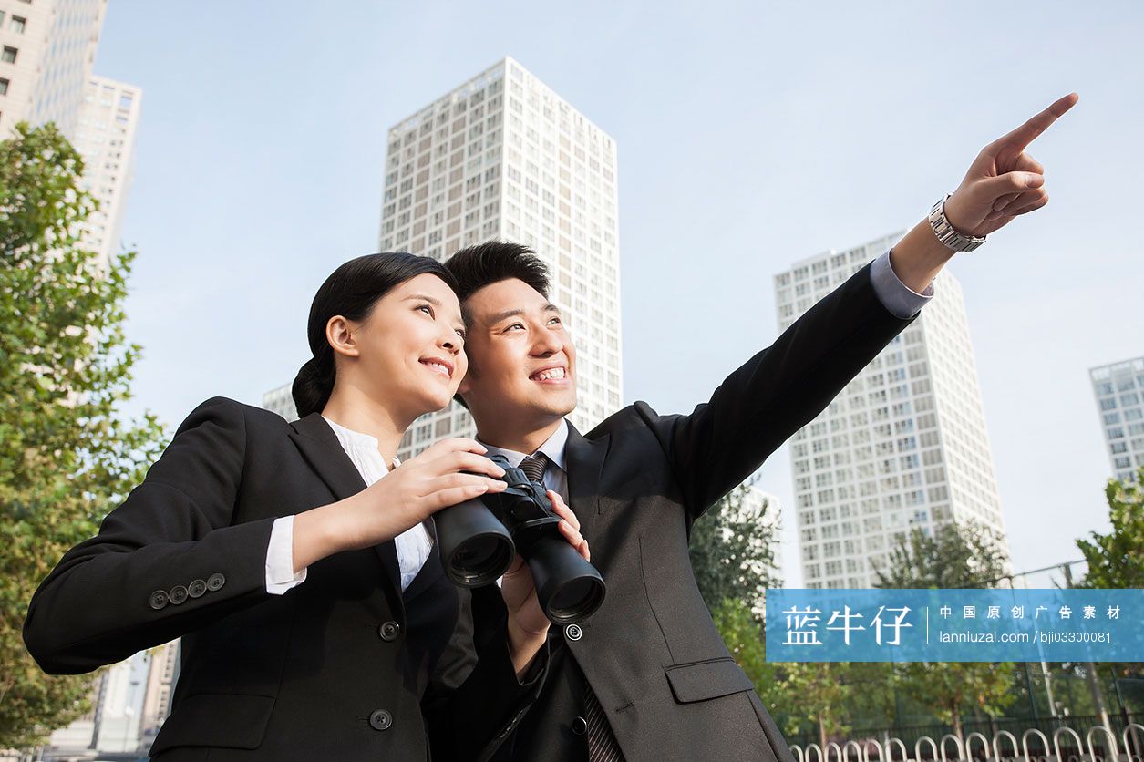 年轻的商务男女和望远镜
