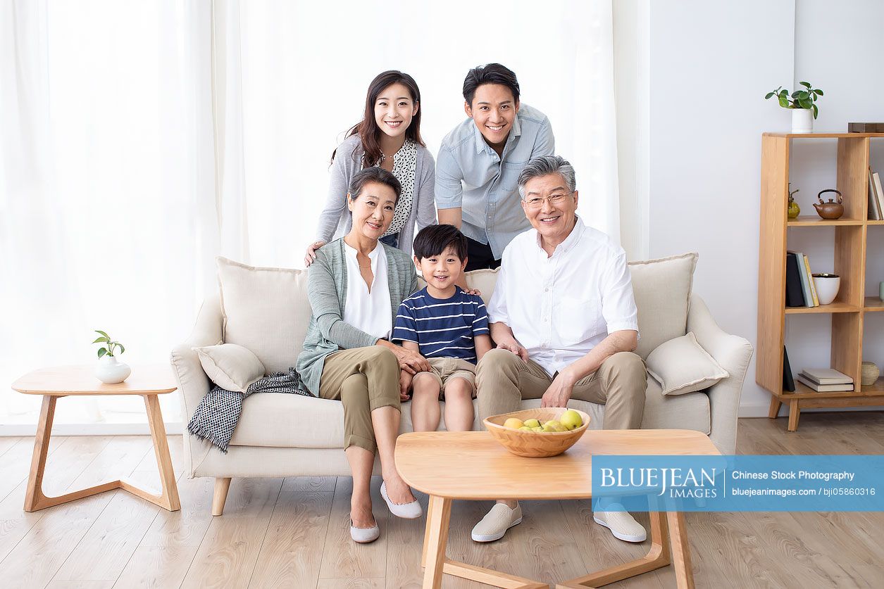 Happy Chinese family relaxing on sofa