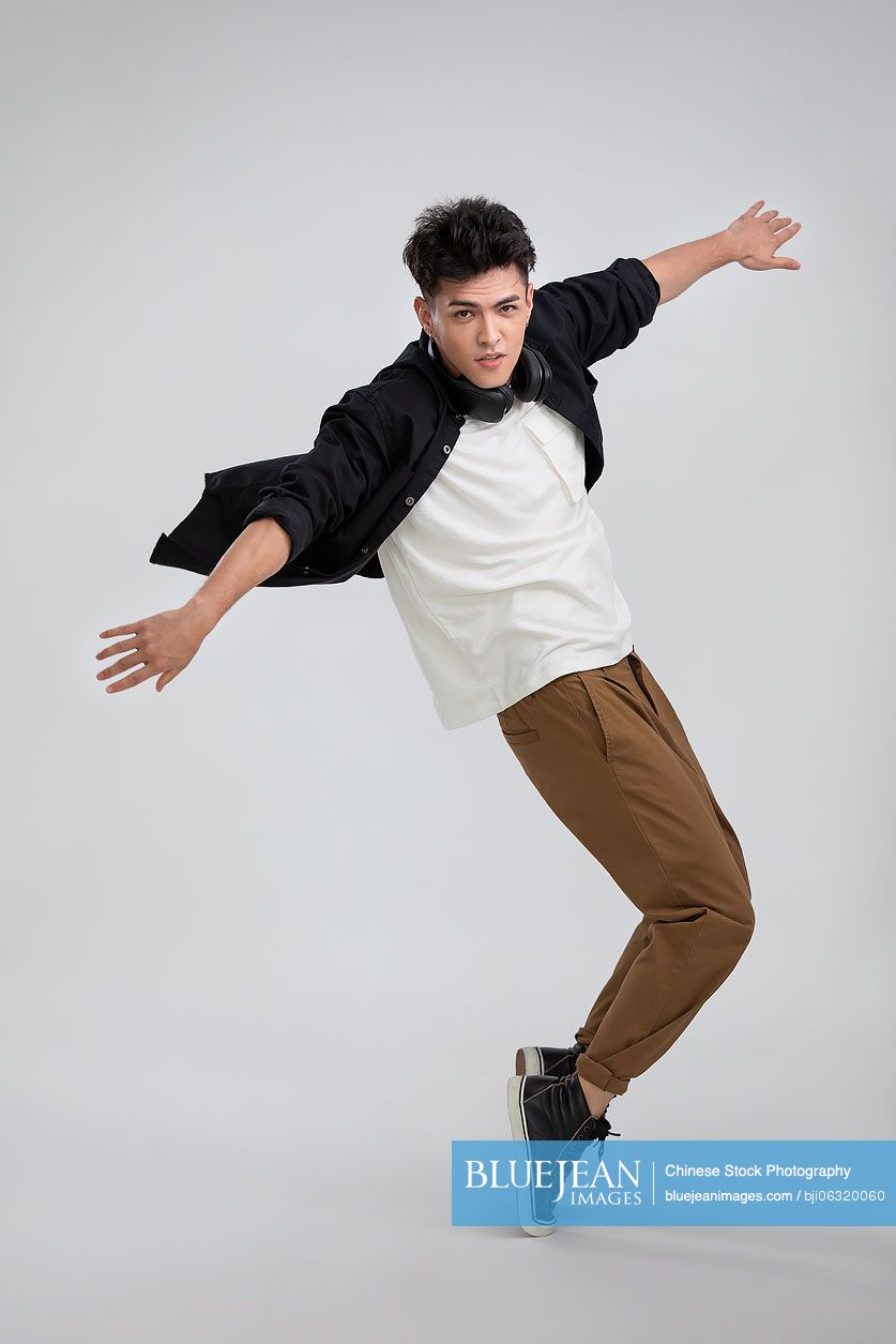 Cool young Chinese man dancing with headphones