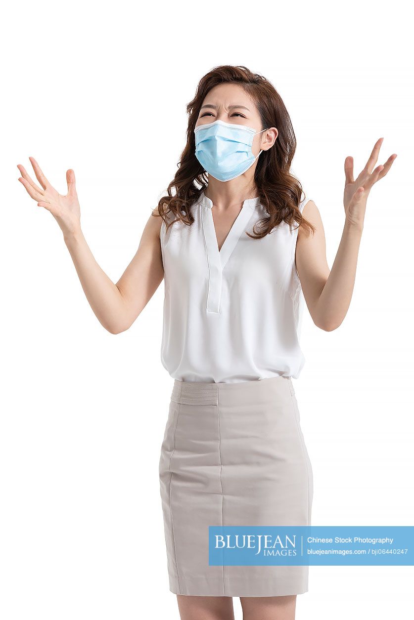 Young Chinese businesswoman with surgical mask in anger