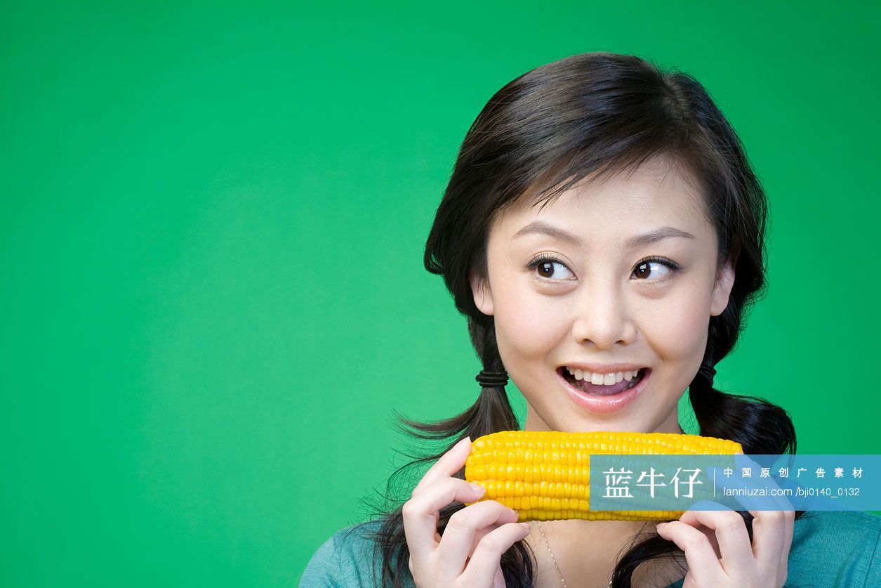 年轻女子吃玉米