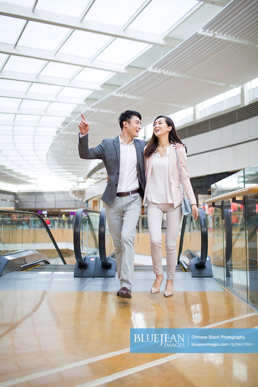 Young Chinese couple walking in shopping mall