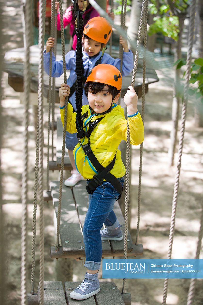 Happy Chinese children playing in tree top adventure park