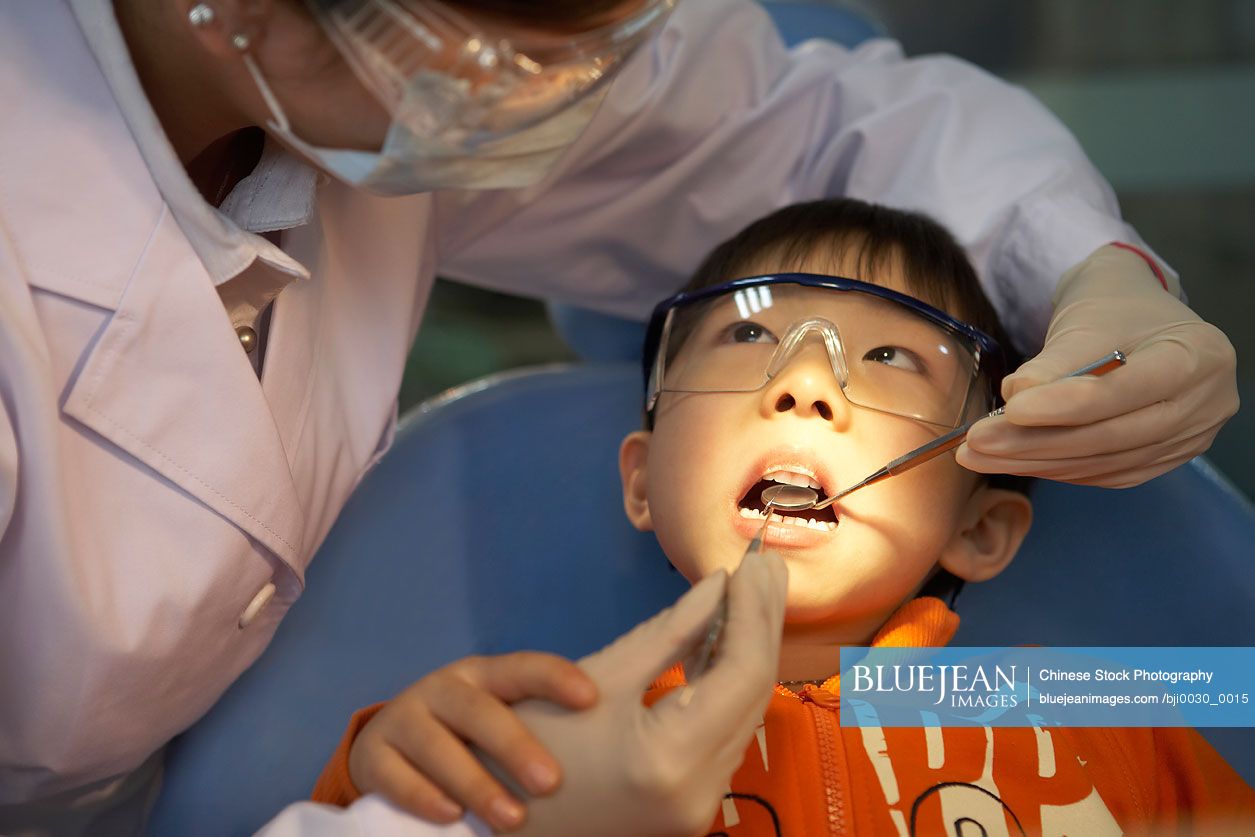 Chinese dentist examining boy's teeth