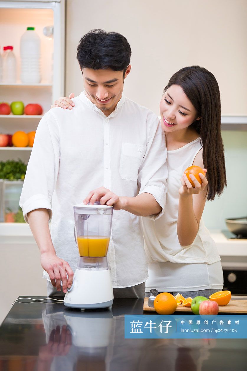 年轻夫妇在厨房使用榨汁机