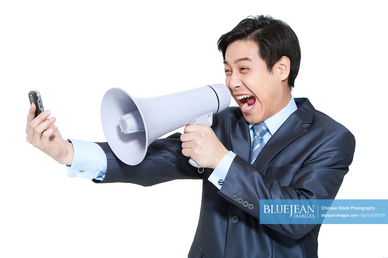 Portrait of a Chinese businessman shouting into a megaphone