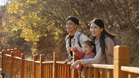 Cheerful young Chinese family enjoying the beautiful natural scenery