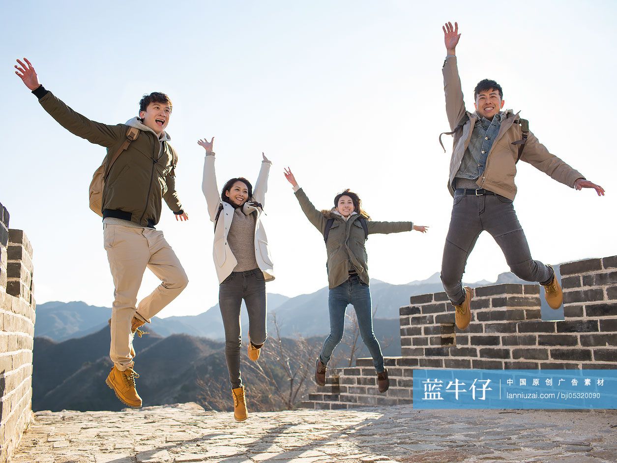Happy young Chinese friends jumping on the Great Wall