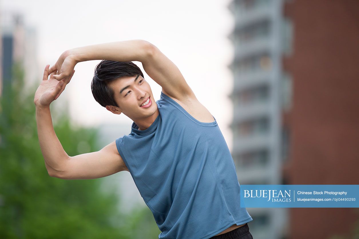 Young Chinese man stretching outside