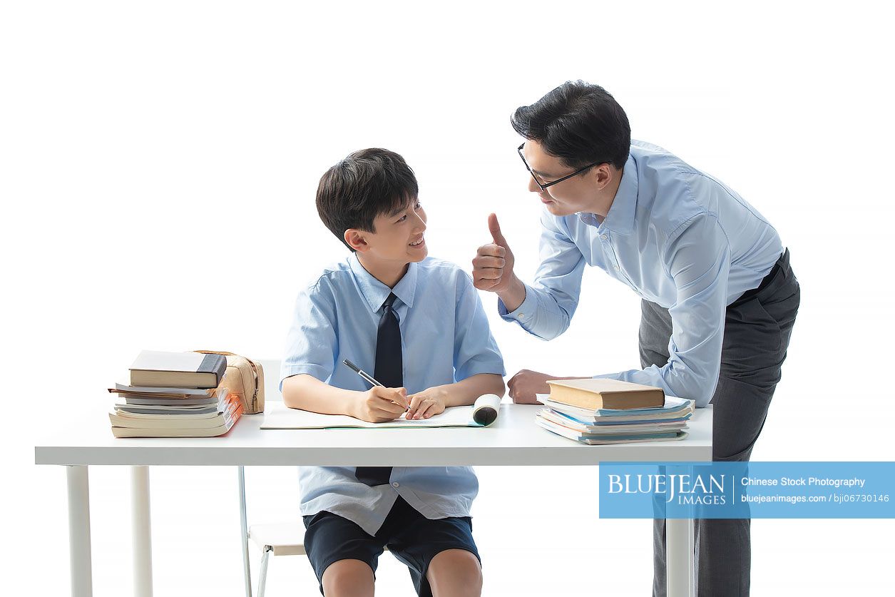 Chinese teacher helping boy with homework