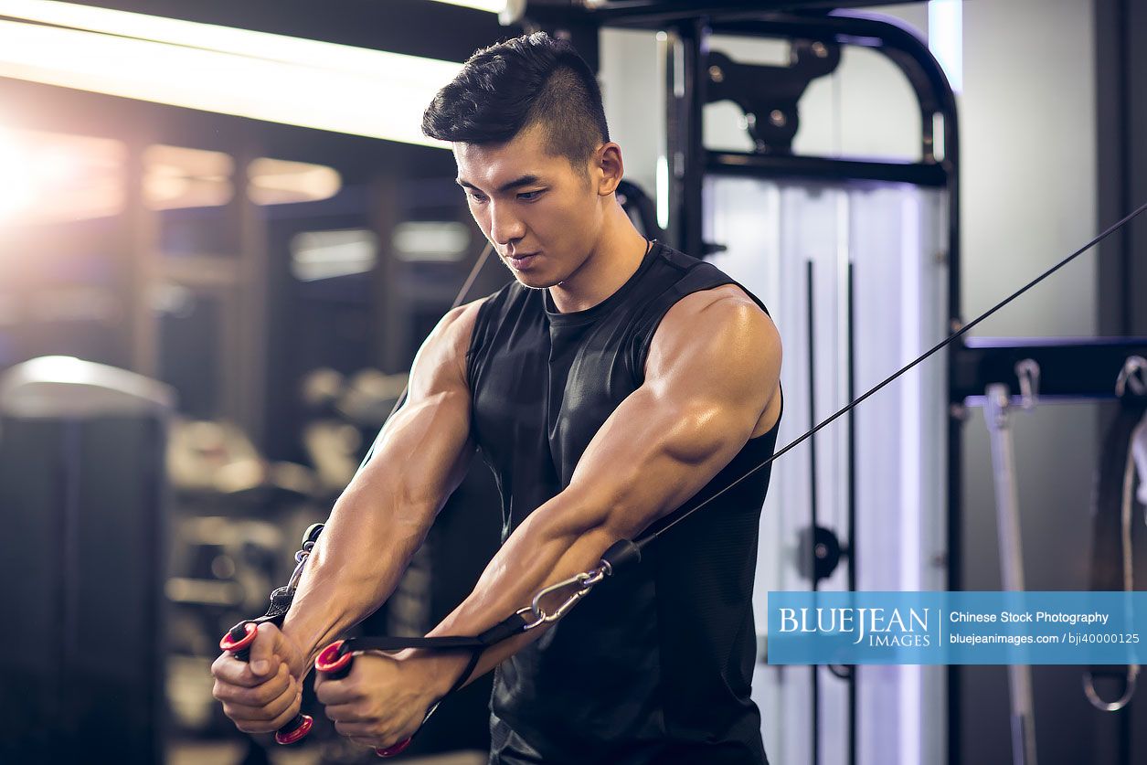 Young Chinese man exercising at gym