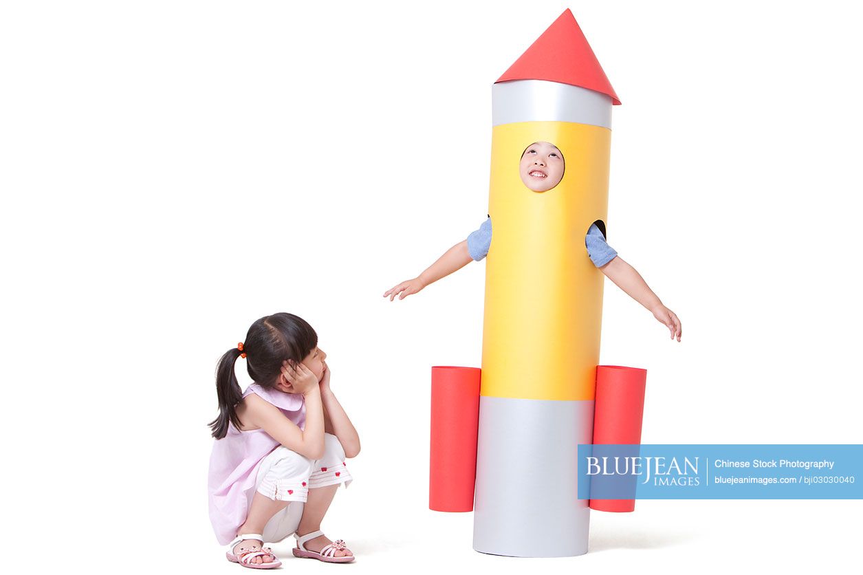 Chinese boy and girl with a toy rocket