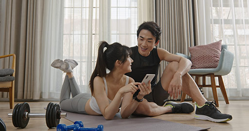 Young Chinese couple using smart phone after exercising,4K