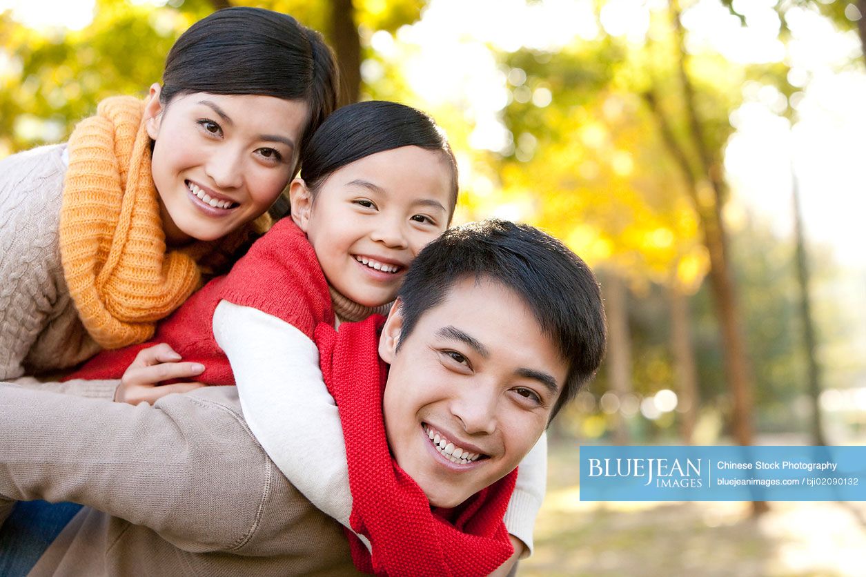 Young Chinese family playing in a park in autumn