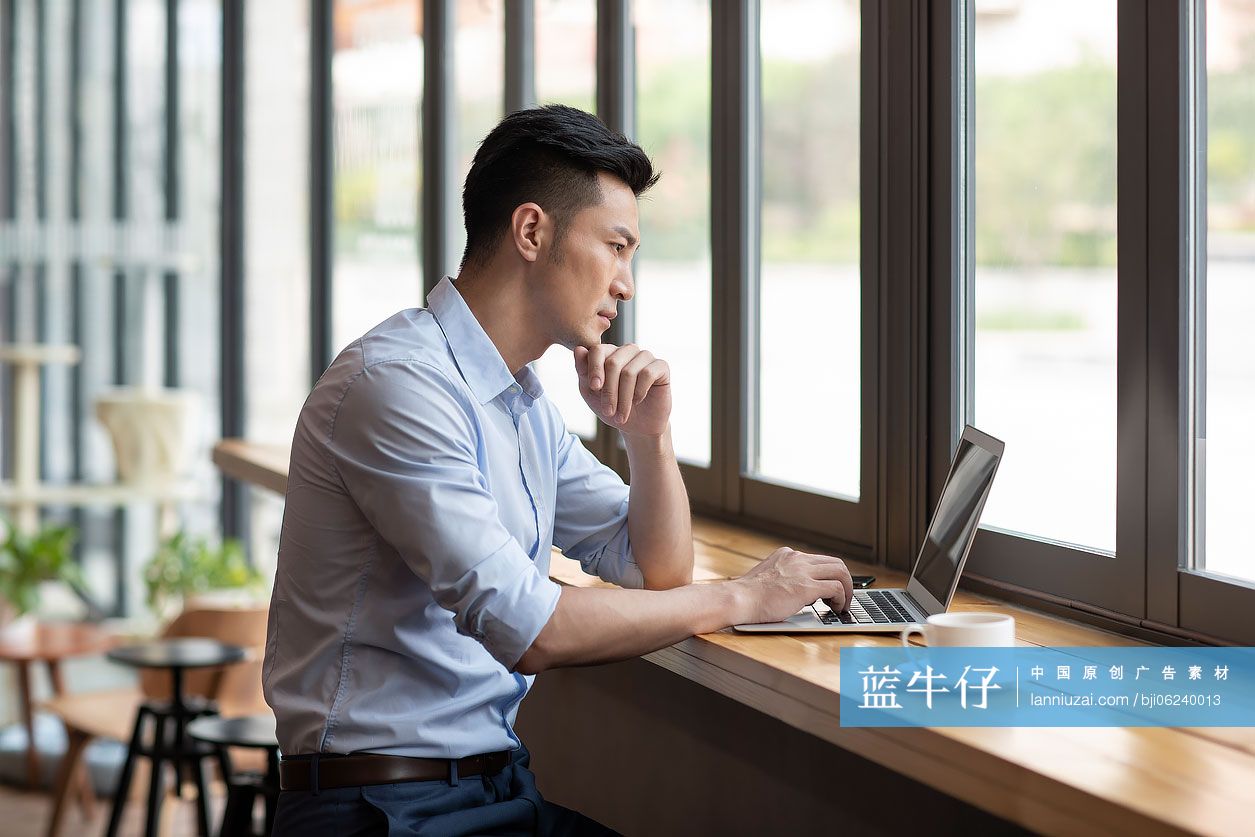 商务男子在咖啡馆使用笔记本电脑工作
