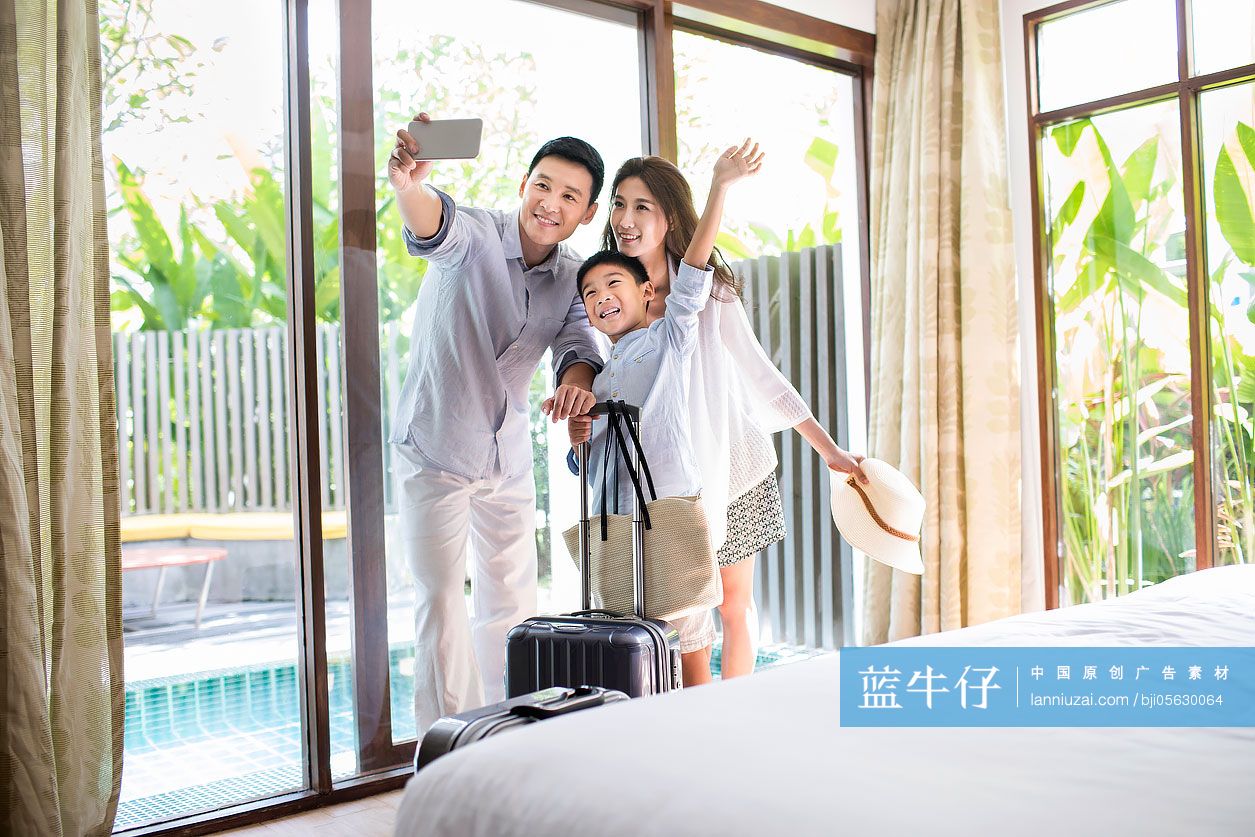 快乐的年轻家庭在酒店房间自拍