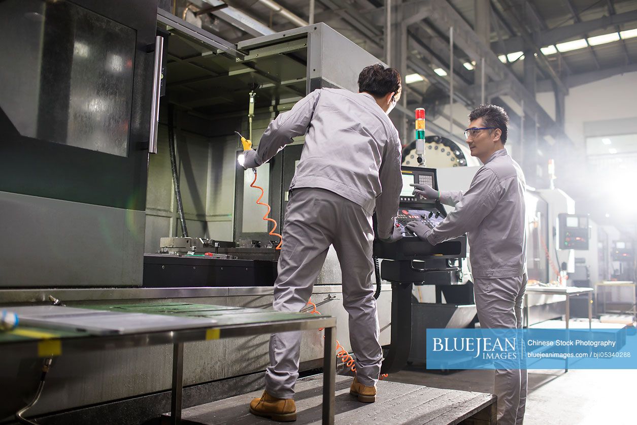 Confident Chinese engineers working in the factory