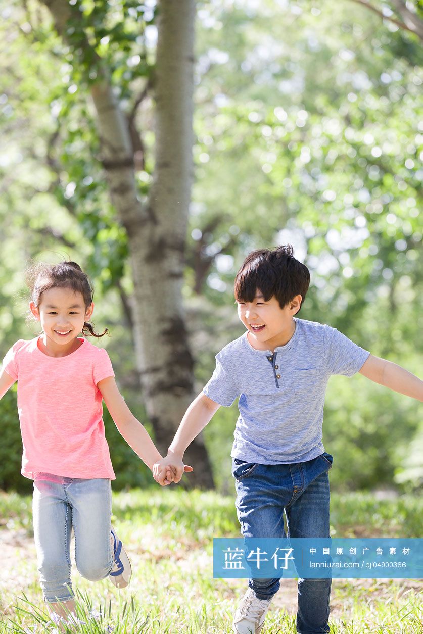 儿童手牵手在树林里奔跑