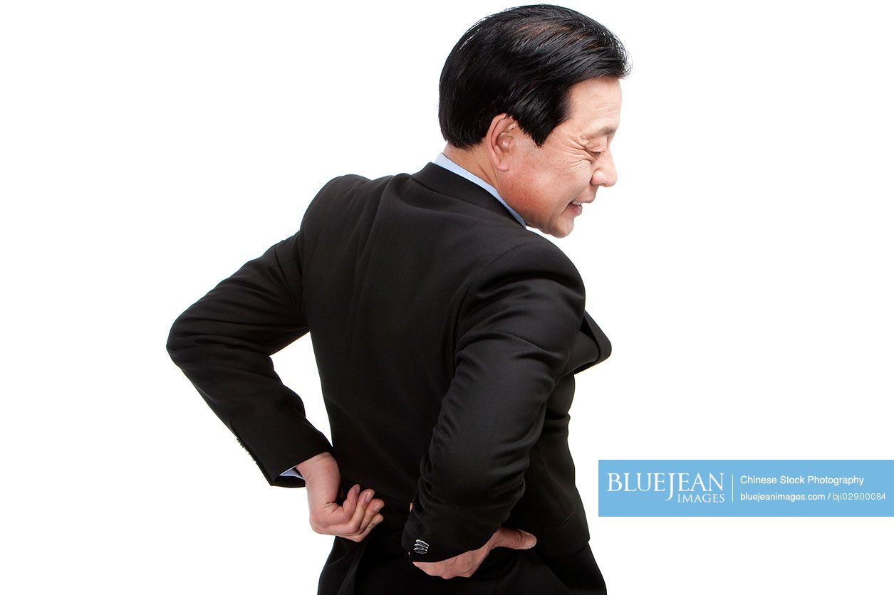 Senior Chinese businessman suffering from low back pain