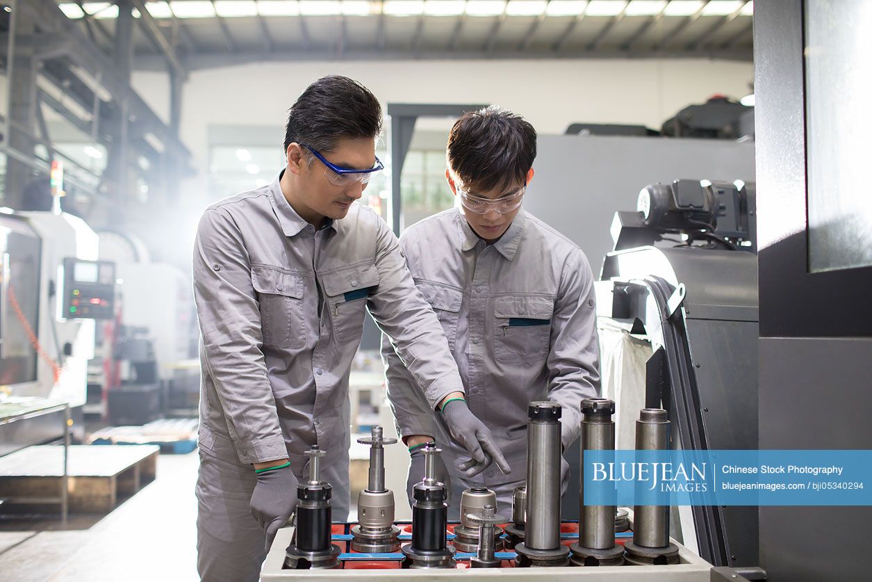 Confident Chinese engineers working in the factory