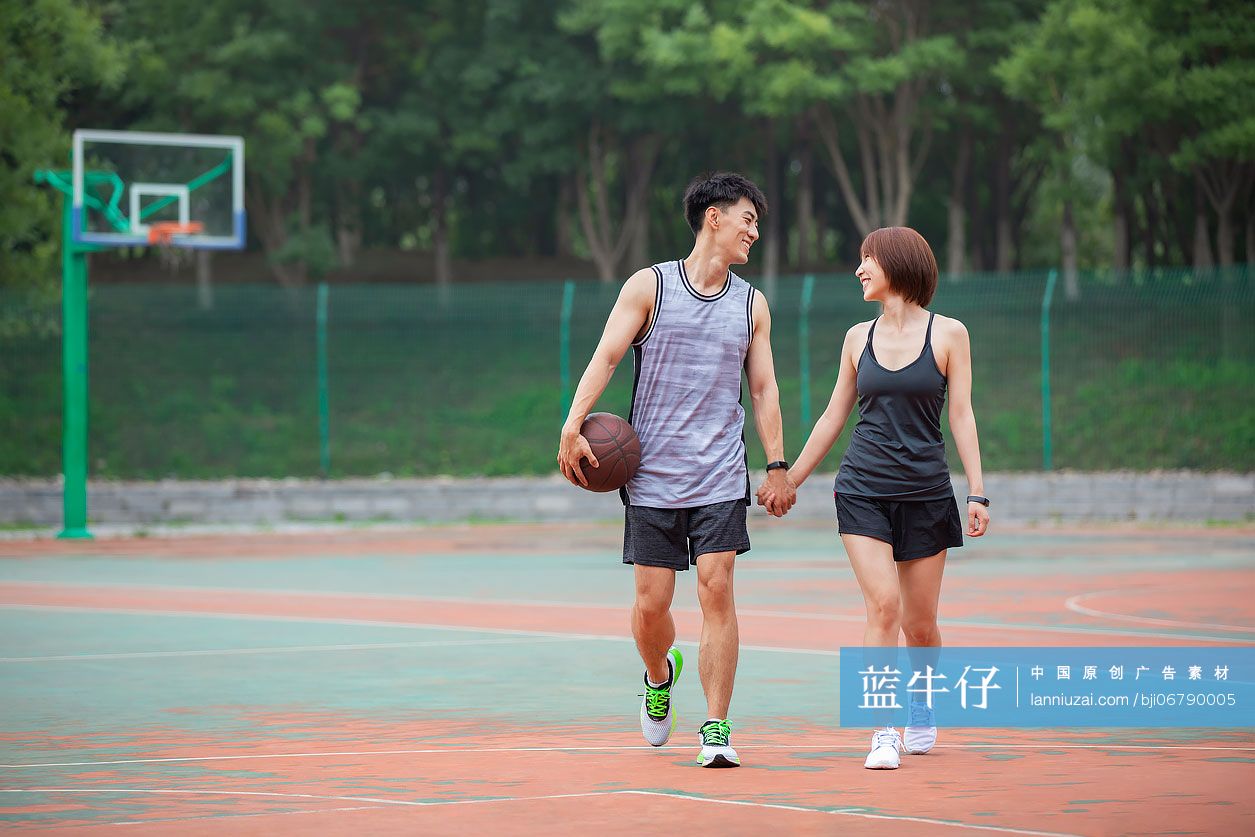 开心的年轻情侣在篮球场打篮球-蓝牛仔影像-中国原创广告影像素材