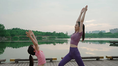 妈妈和女儿在公园练瑜伽