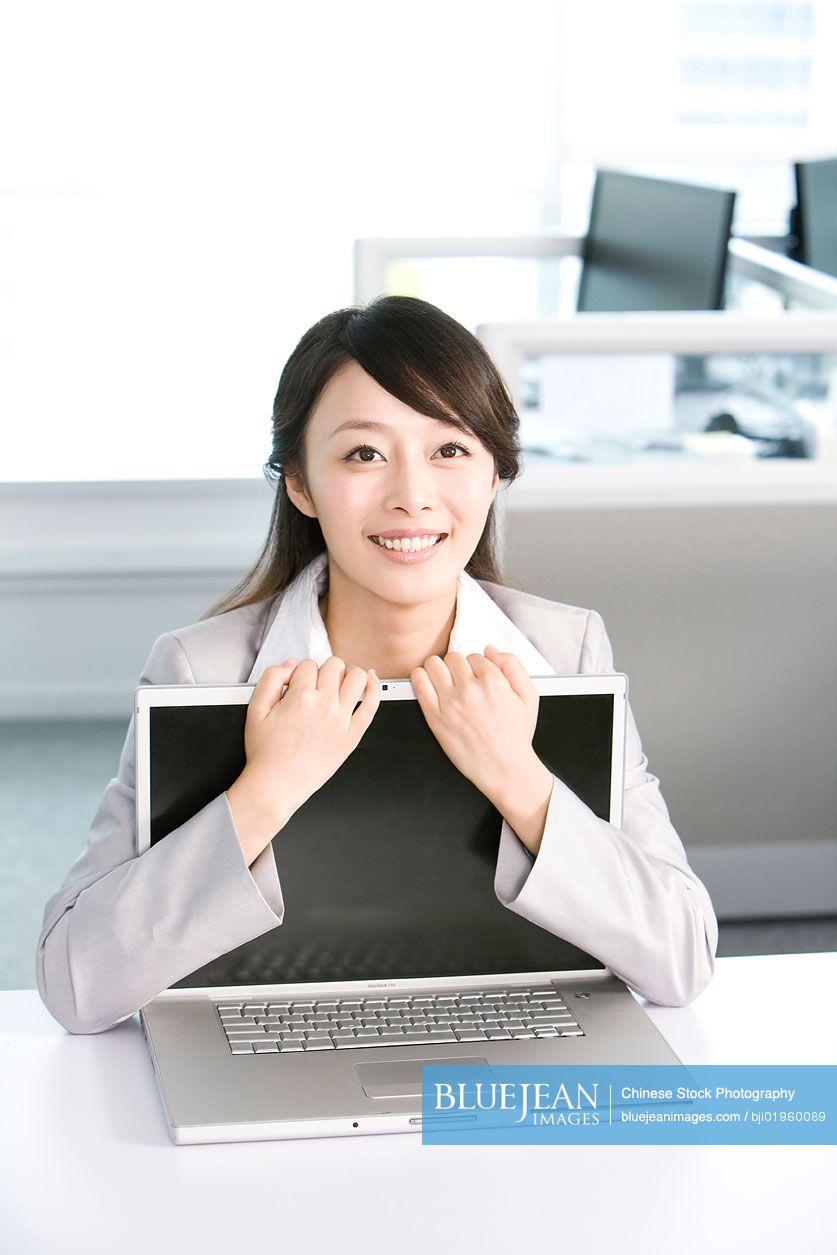 Chinese office worker hugging her computer