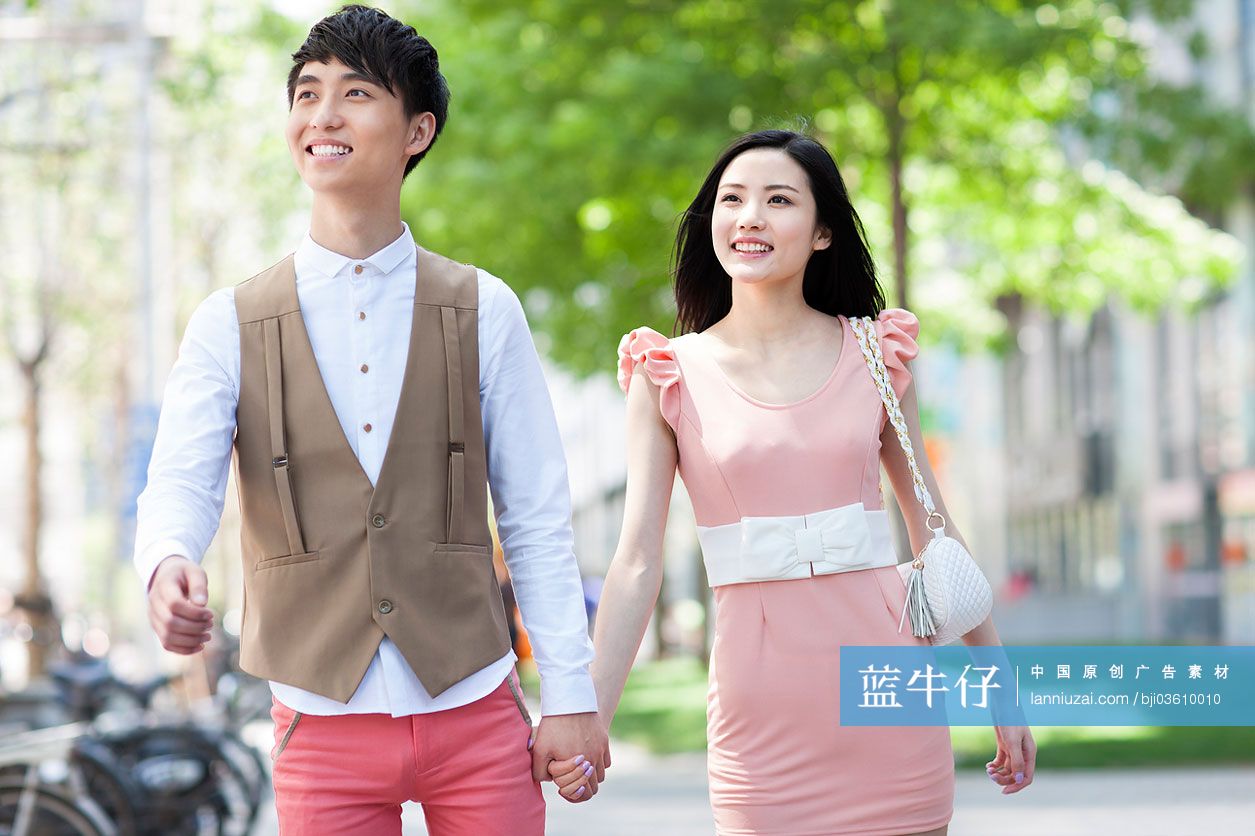 时尚年轻情侣手牵手走路