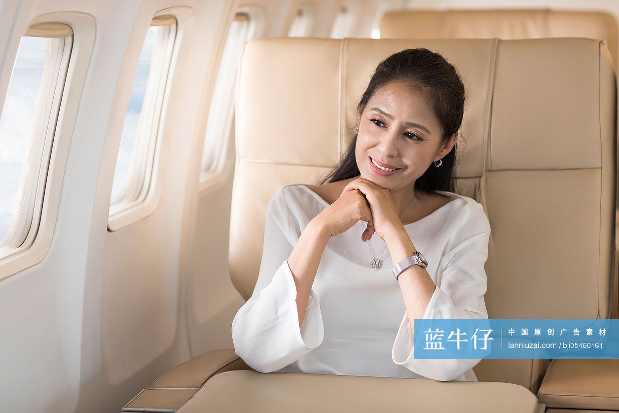 优雅的中年女士欣赏飞机窗外的风景