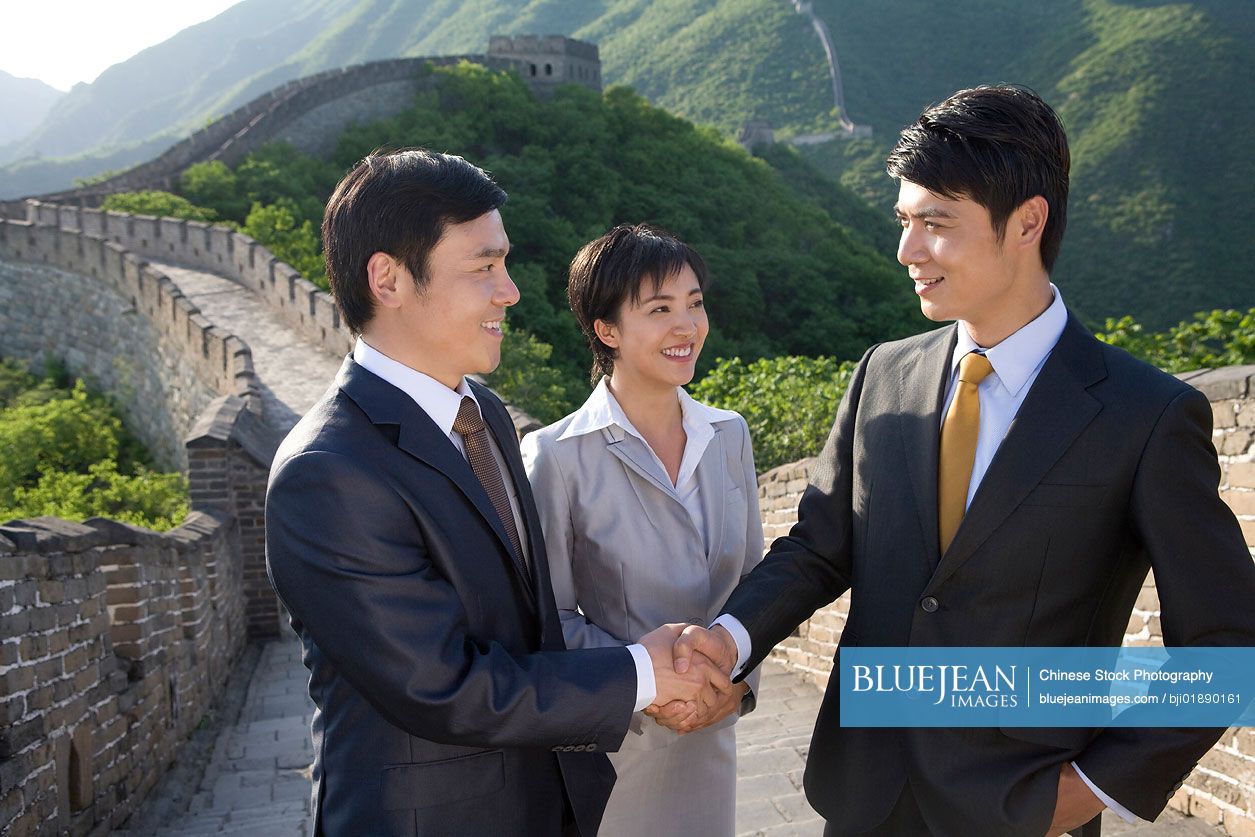 Chinese businessmen shaking hands on the Great Wall